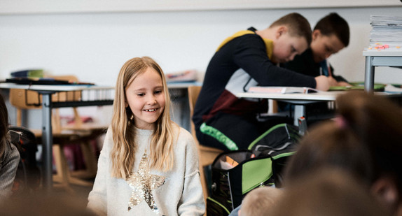 Schülerinnen und Schüler in einem Schulraum